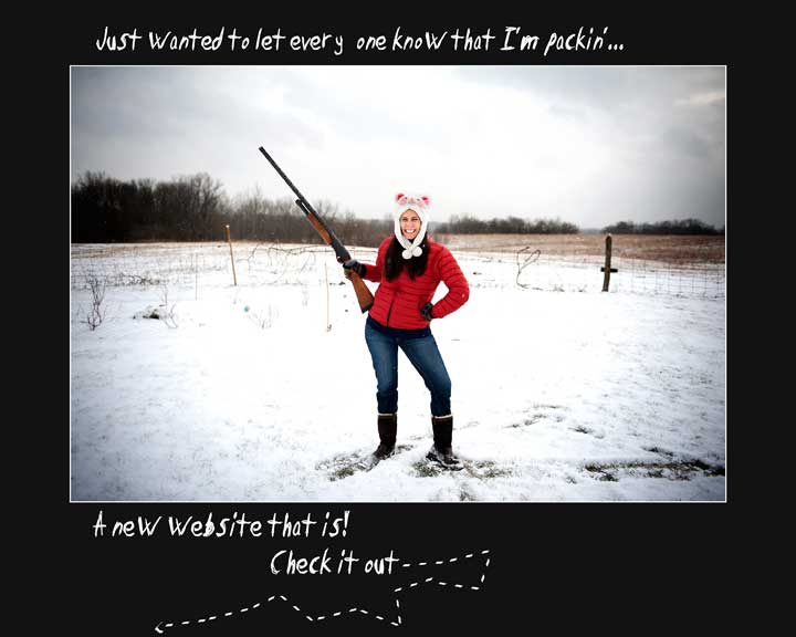 Girl standing in snowy field, smiling while holding shotgun pointed at sky