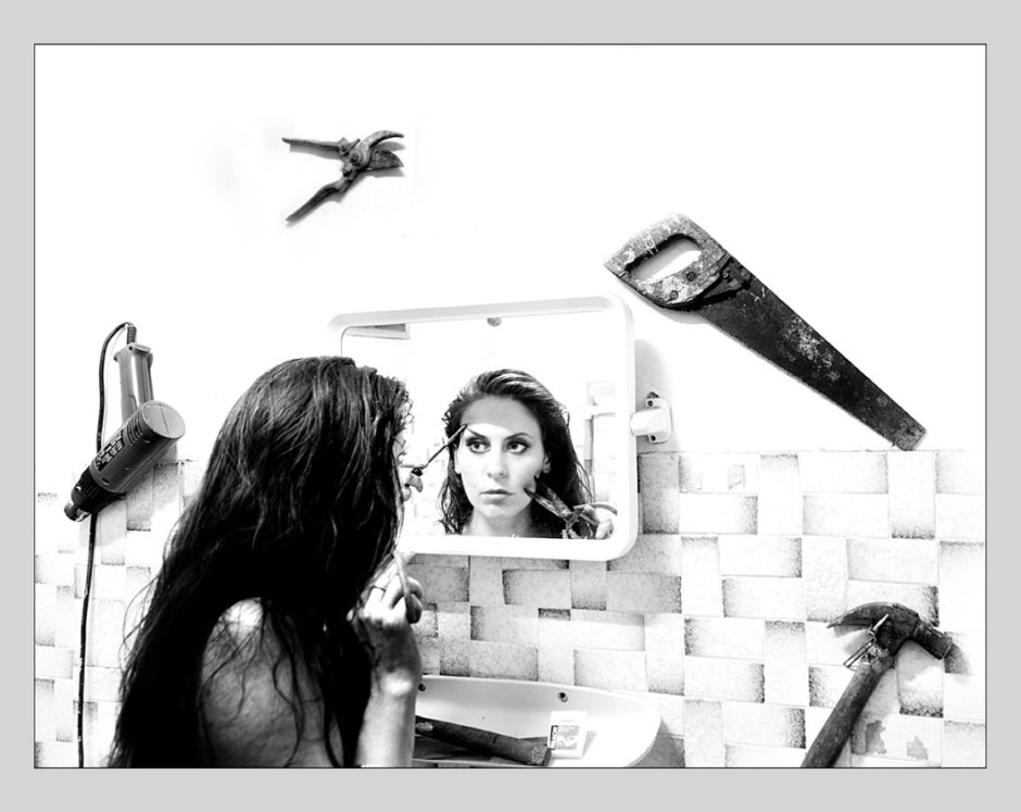 Girl looking in mirror, applying makeup